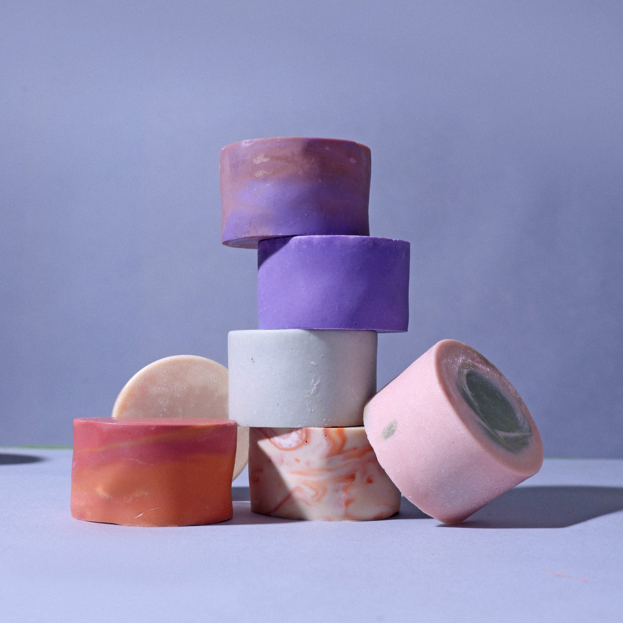 Colorful round artisan soaps with swirling designs in a rectangular gift box